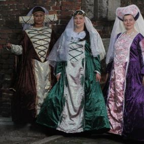 Drie vrouwen in middeleeuwse kostuums