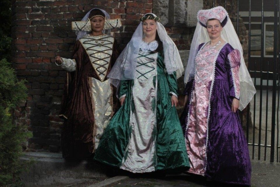 Drie vrouwen in middeleeuwse kostuums