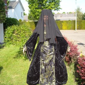 Vrouw in zwarte middeleeuwse jurk